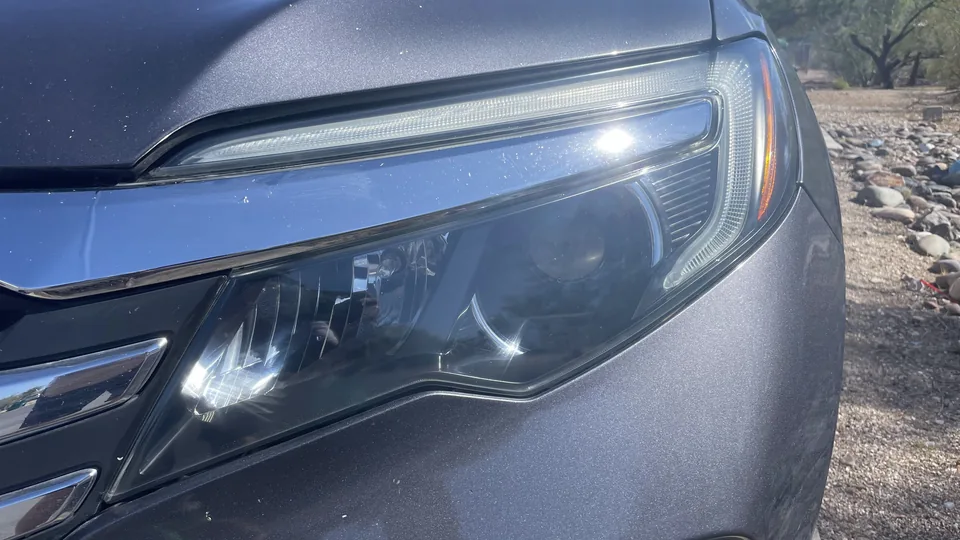 After view of the same headlight lens appearing clearer with internal lamp elements more visible.